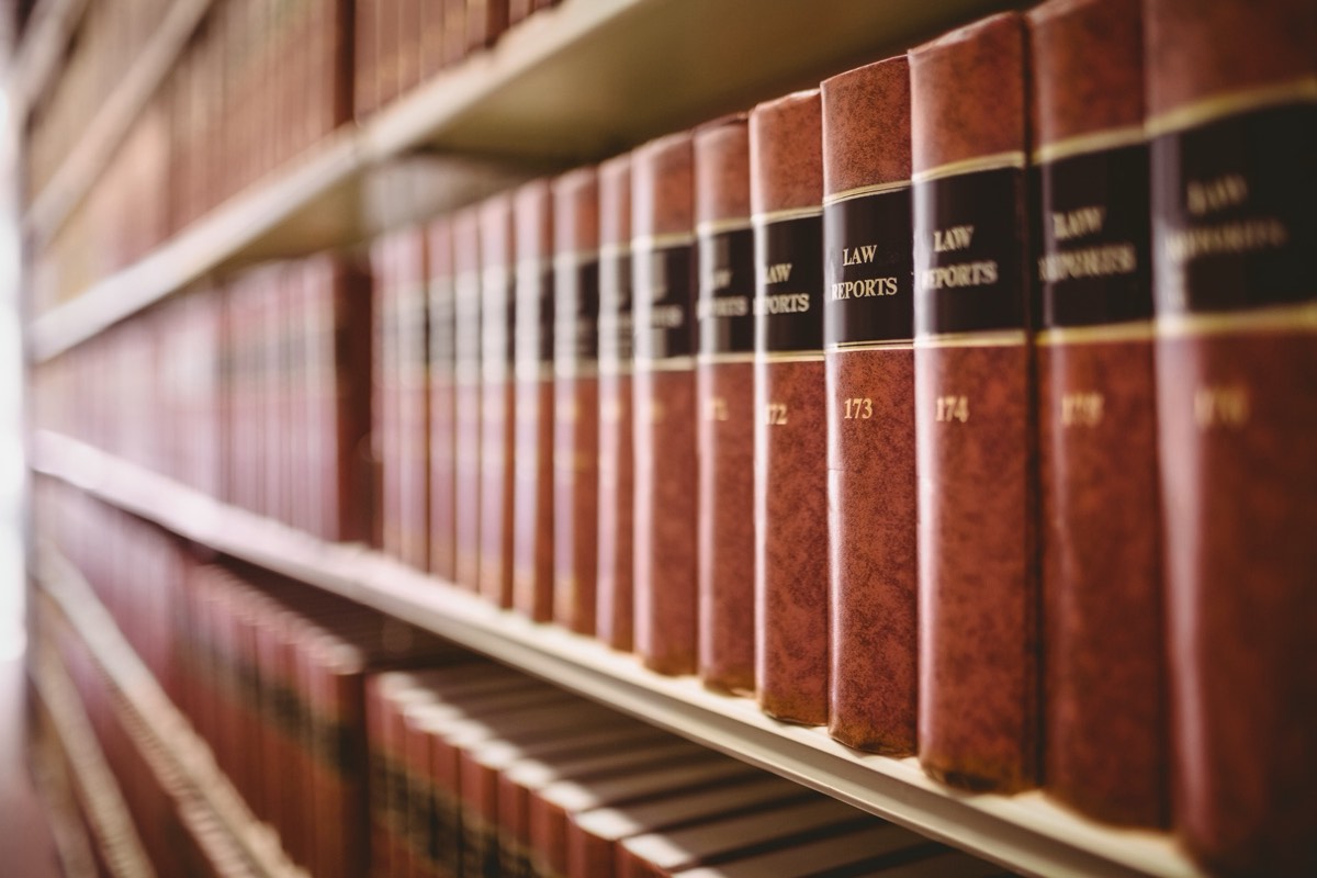 Rows of bound state statutory code volumes on a law library shelf