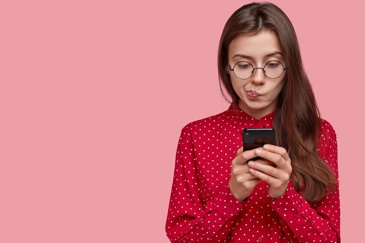 A smartphone showing a social media photo feed beside lines of HTML embed code on a screen