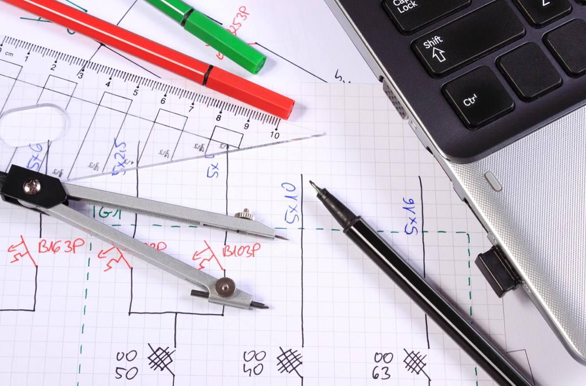 Product design sketches beside engineering drawings on a desk