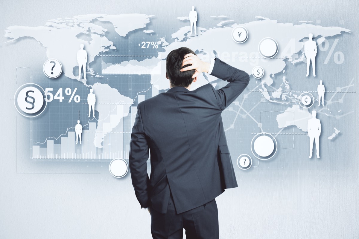 International business owner reviewing trademark application paperwork at a desk with a world map
