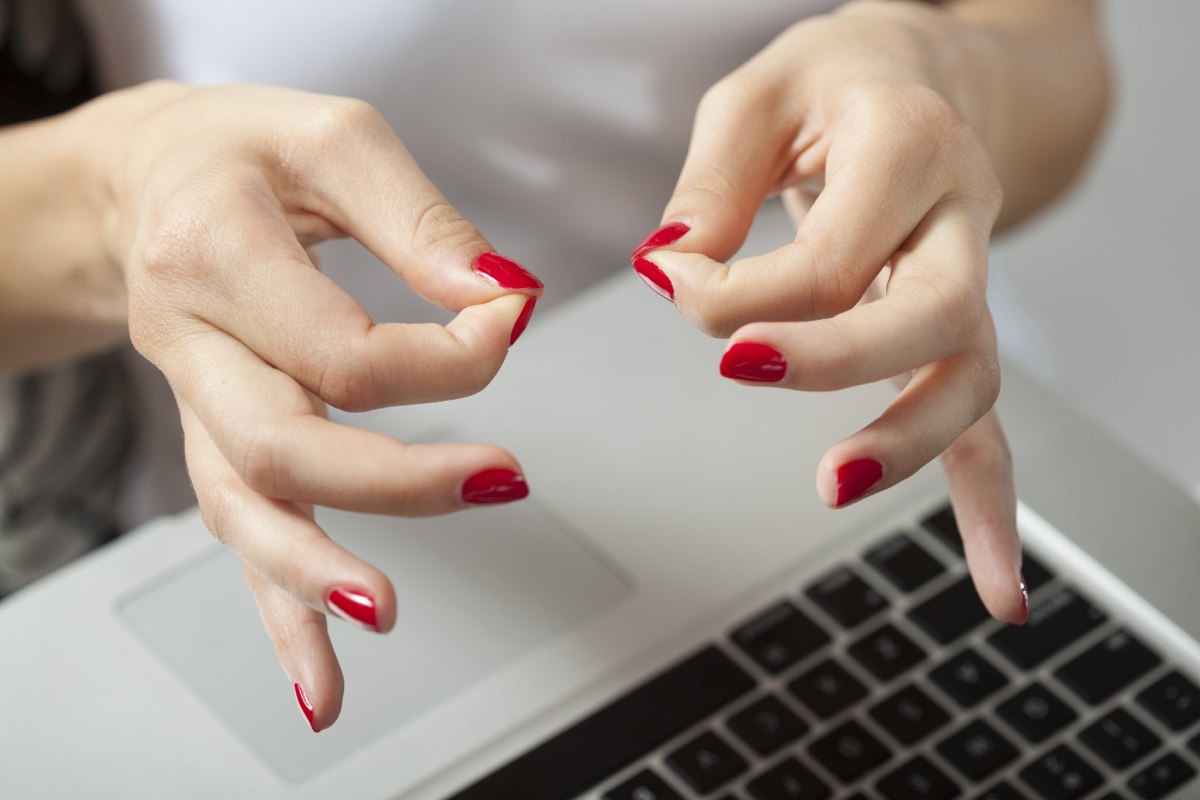 Person typing a website domain name into a browser address bar on a laptop
