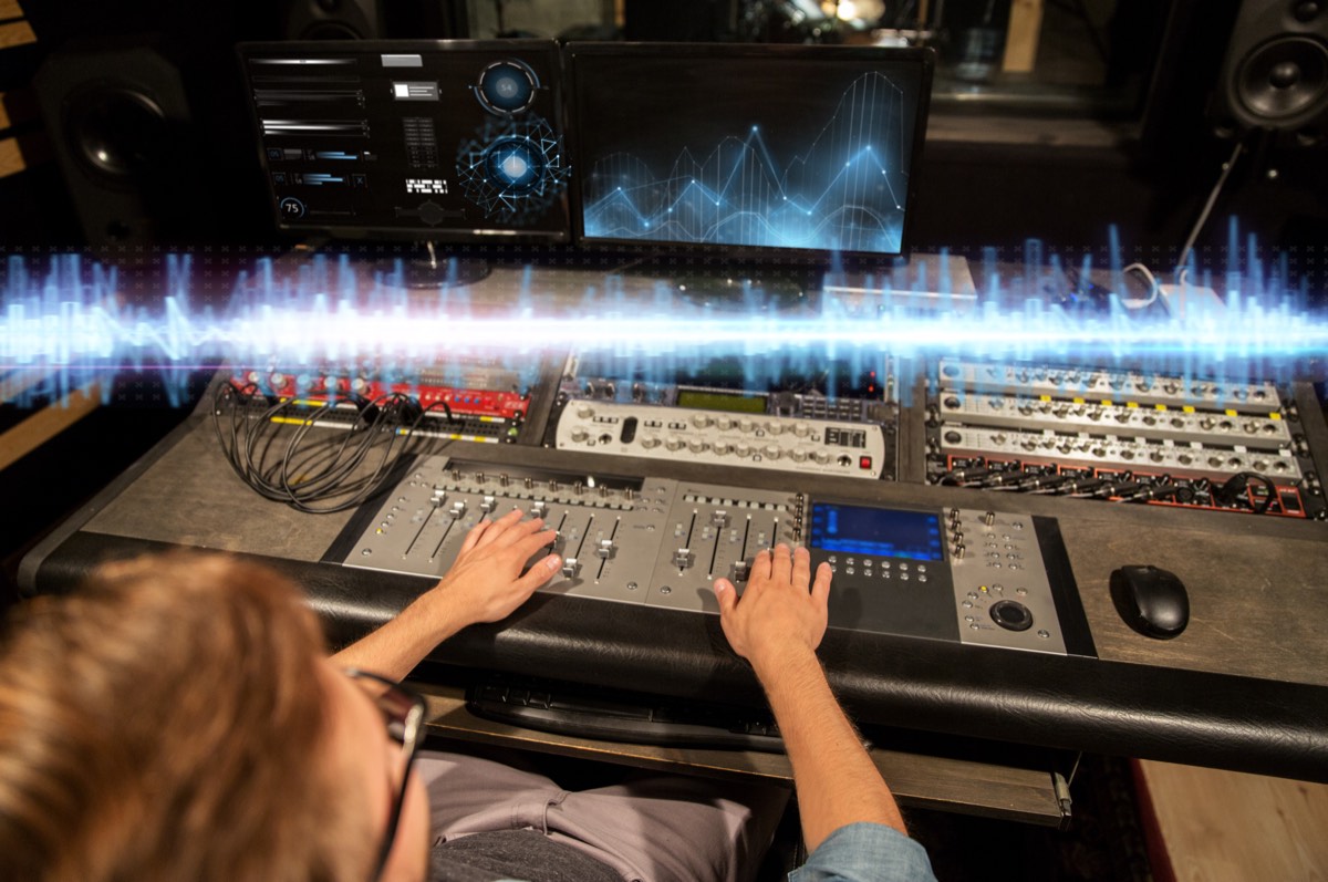 Music producer working at a recording studio mixing console