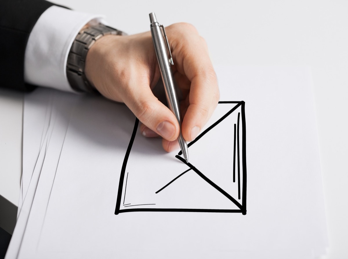 Sealed mailing envelope resting on a hand-drawn invention sketch