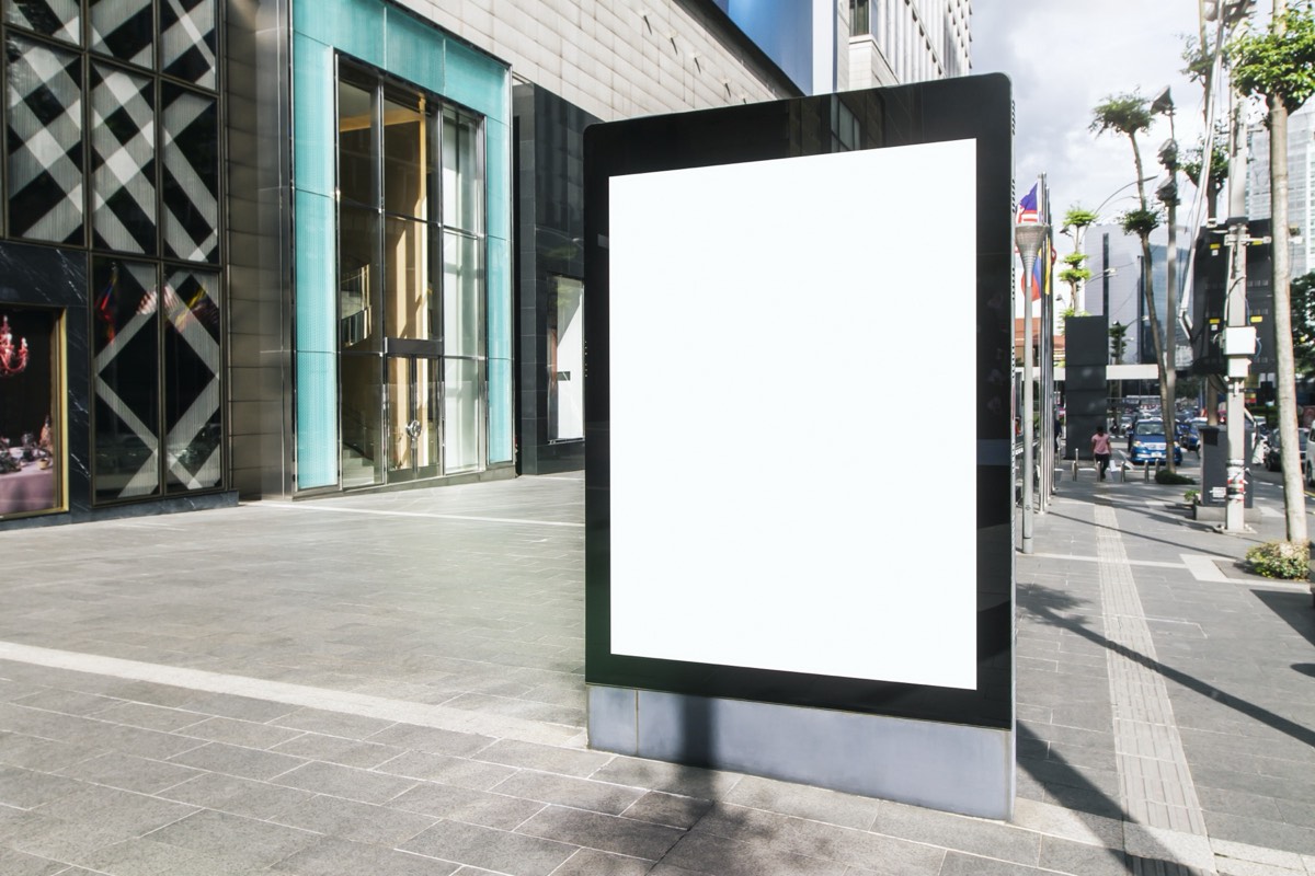 Large billboard advertisement showing a person's face above a busy city street