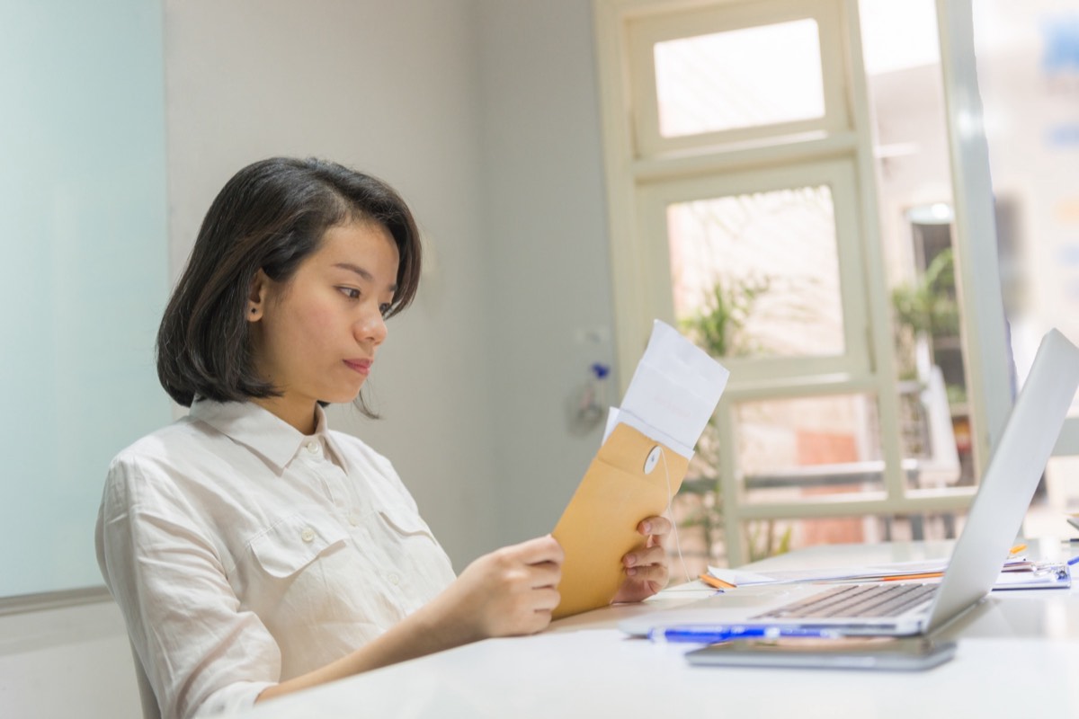 Person opening a formal legal letter at a desk