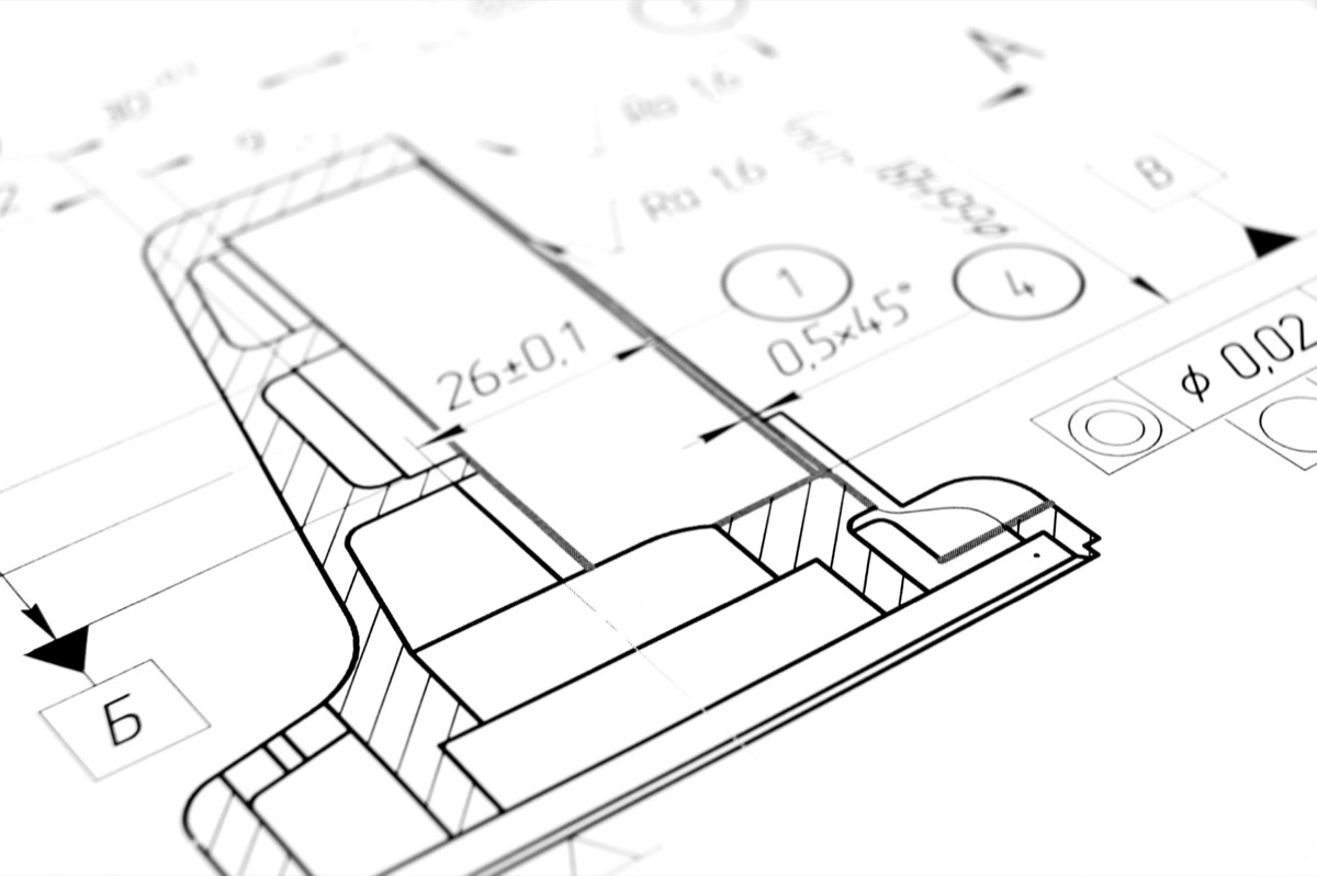 Open technical patent document with engineering drawings and a magnifying glass