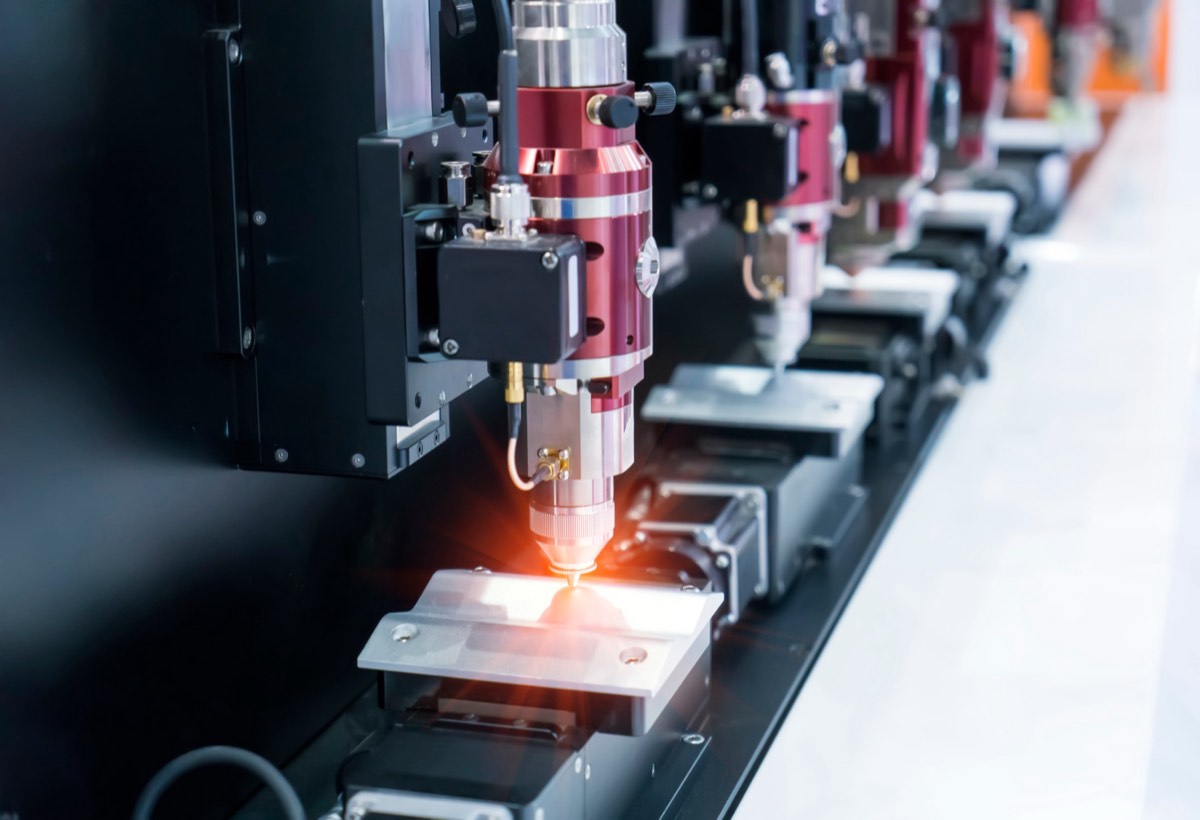 A laser projector casting alignment lines across an industrial work surface
