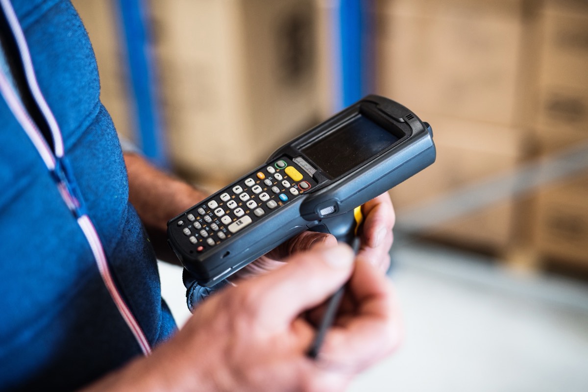 Barcode scanner reading a product label on a warehouse conveyor