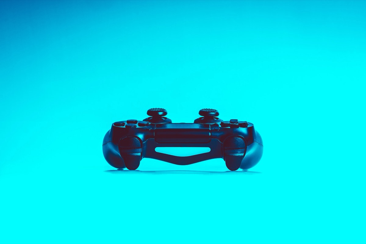 Game controller resting on a dark desk beside a keyboard