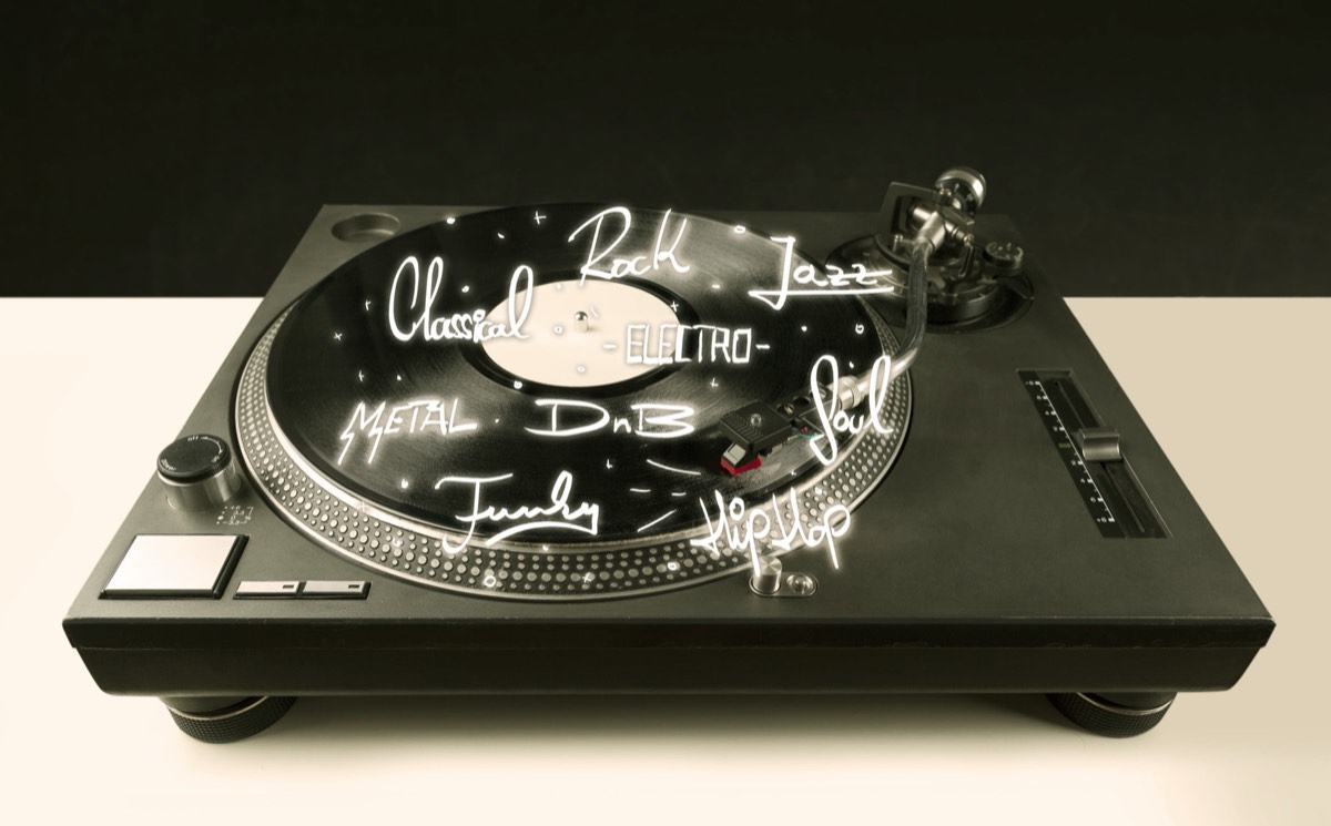 A vinyl record spinning on a vintage turntable beside a pair of go-go boots