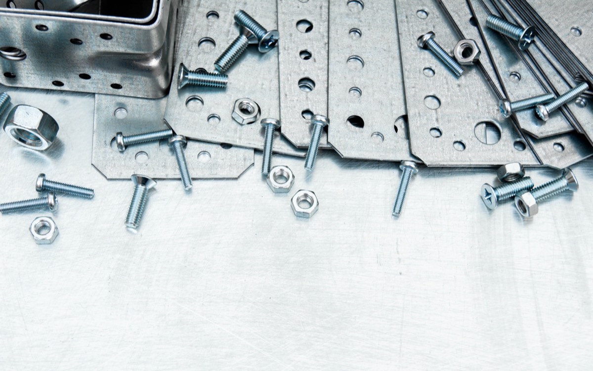 Rows of metal fasteners and screws on an industrial workbench